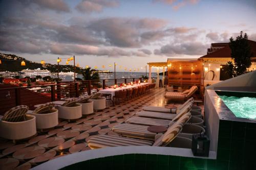 a rooftop patio with lounge chairs and a swimming pool at The Pink Palm Hotel - Adults Only in Charlotte Amalie