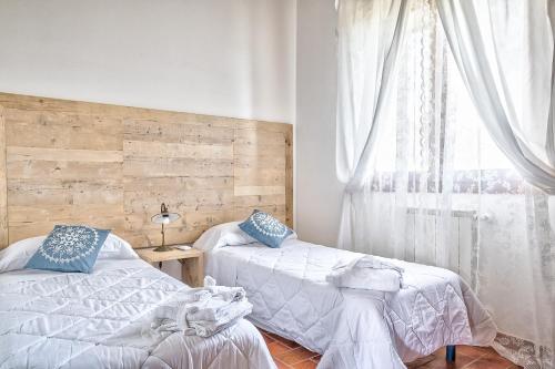 a bedroom with two beds and a window at Borgo del Faggio - Case Vacanza in Montepulciano