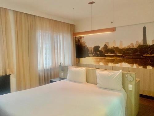Una cama blanca grande en una habitación con ventana. en Suites Inside Hotel Patio Paulista, en São Paulo