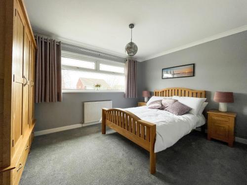 a bedroom with a bed and a window at Well Situated, Cosy 2 Bed House in West Kirby