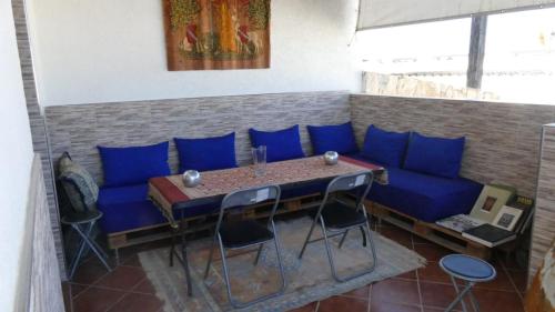 a room with a blue couch and a table and chairs at Apartment Amira Smir in Riffiene