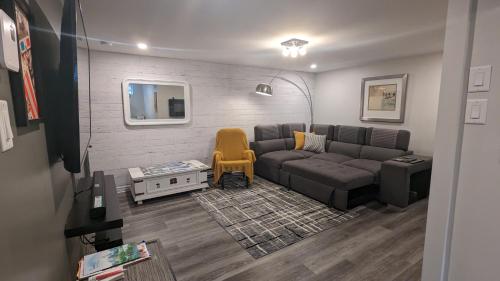 a living room with a couch and a yellow chair at Simplement l’Harmonie à Chambly in Chambly