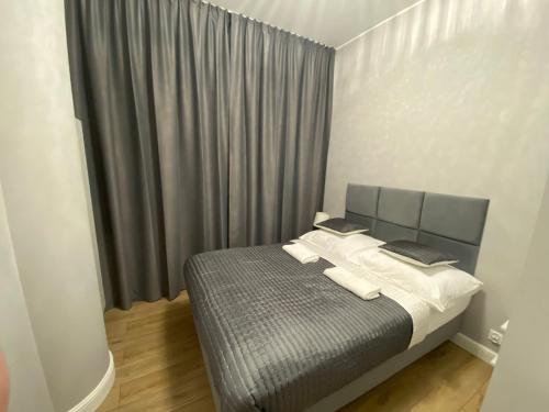 a bedroom with a bed and a window with curtains at HANZA TOWER HIGH FLOOR Swimming Pool & Spa in Szczecin