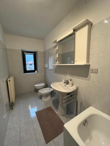 a white bathroom with a sink and a toilet at Appartamenti Le Calle in Nago-Torbole