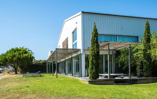 un bâtiment avec des arbres devant dans l'établissement Villa Waterfront - Villa with spectacular views and direct access to the laguna, à Balaruc-les-Bains