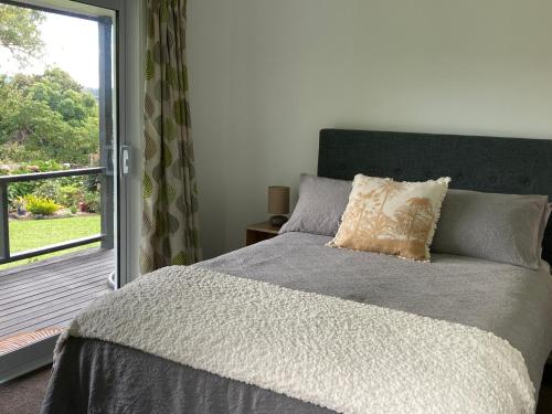 a bedroom with a bed and a sliding glass door at Kauri Point Village in Tahawai