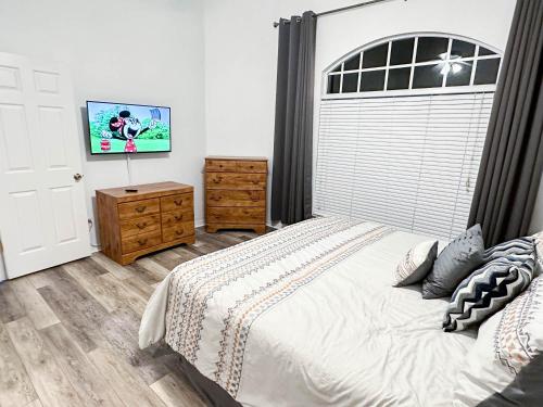 a bedroom with a large bed and a tv at Affordable Luxury Home Near Walt Disney World - Sunshine Villa at Glenbrook Resort, Orlando, Florida in Orlando