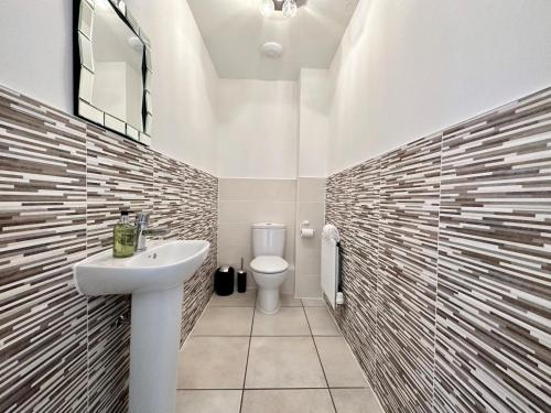 Baño blanco con lavabo y aseo en Homely 3 bedroomed House in Bicester, en Bicester