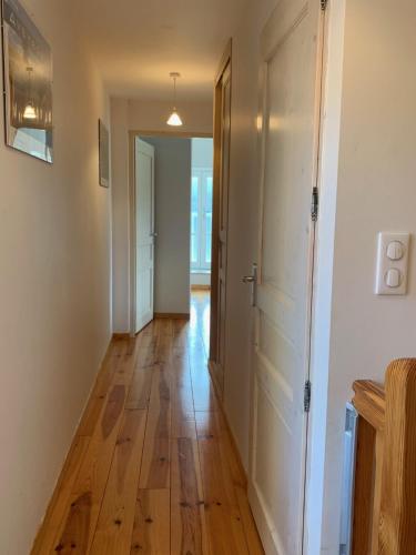 a hallway with a hard wood floor and a door at Gîte l'oustal de la fontaine Grand Causses et Gorges du Tarn in Mostuéjouls