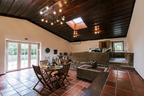 a living room with a wooden ceiling and a table at Country Village Senses - Quinta Exclusiva in Reguengo Grande