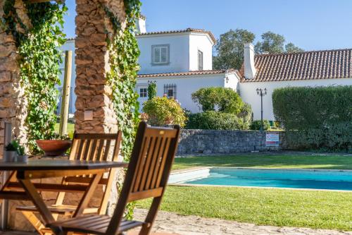 a table and chairs in front of a house at Country Village Senses - Quinta Exclusiva in Reguengo Grande