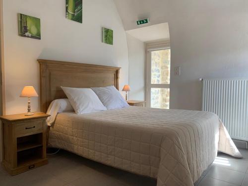 Un dormitorio con una cama grande y una ventana en Gîte l'oustal de la fontaine Grand Causses et Gorges du Tarn, en Mostuéjouls
