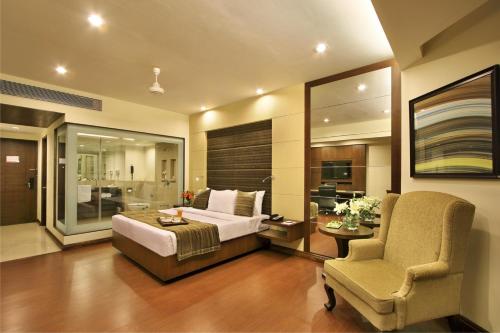 a bedroom with a bed and a chair and a desk at Hotel Express Residency Vadodara in Vadodara