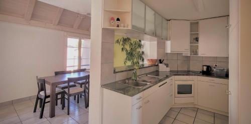 a kitchen with white cabinets and a table with a dining room at Aquae Helveticae in Baden