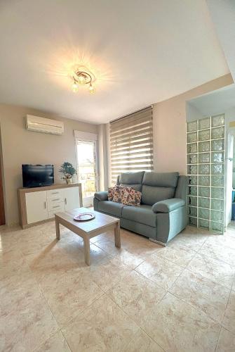 een woonkamer met een bank en een salontafel bij Apartamento MariaLuisa in Oliva