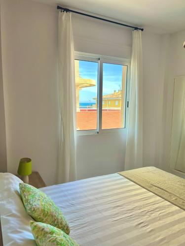 een slaapkamer met een bed en een raam bij Apartamento MariaLuisa in Oliva