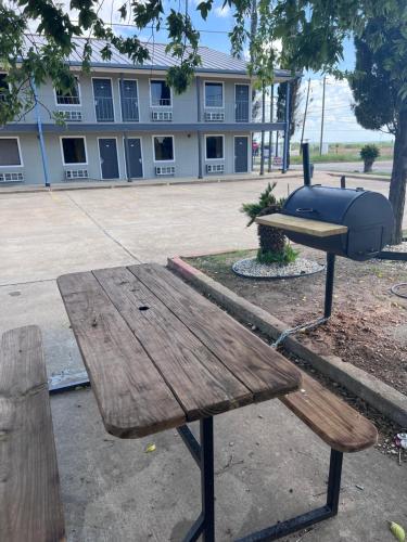 a picnic table with a grill on top of it at Coachway Inn in Luling