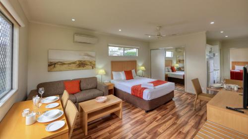 a hotel room with a bed and a living room at Chinchilla Motor Inn in Chinchilla