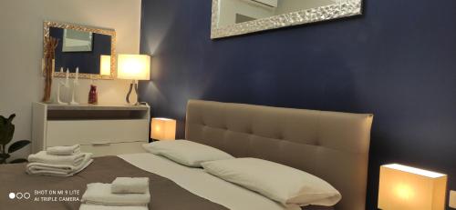 a blue bedroom with a bed with towels on it at Urban Loft in Trieste