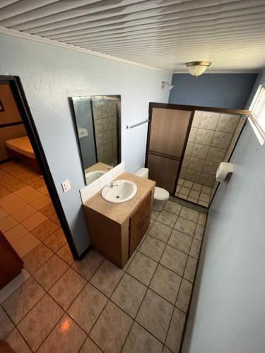 La salle de bains est pourvue d'un lavabo et de toilettes. dans l'établissement Hotel Wilson Tulipan Los Chiles, à Los Chiles