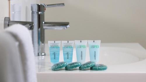 a group of green toothbrushes sitting next to a sink at Chinchilla Motor Inn in Chinchilla