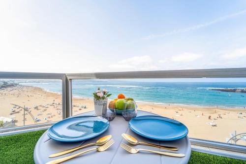 a dining table with a view of the beach at El 5º Cielo in Las Palmas de Gran Canaria