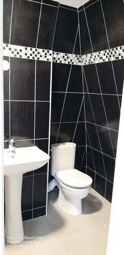 La salle de bains est pourvue de toilettes et d'un lavabo. dans l'établissement Equipée 1 pièce proche Paris, à Argenteuil