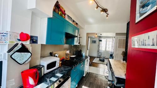a kitchen with blue cabinets and a counter top at Appartement Bleu du Palais - Relaxation Centrale in Le Palais