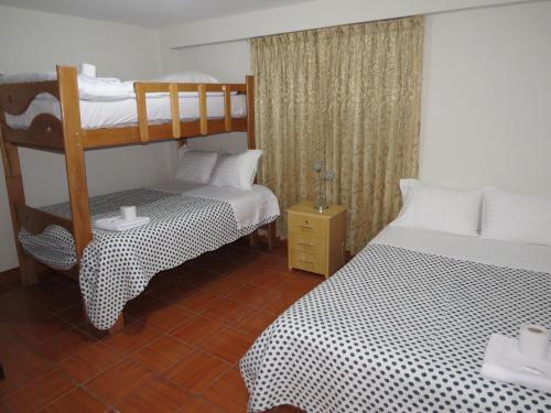 a bedroom with two bunk beds and a wooden floor at Hospedaje El Rinconcito in Jauja