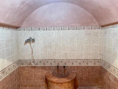 een badkamer met een houten bad en een douche bij Au Cœur Des Plages de Rabat in Oulad Kerroum