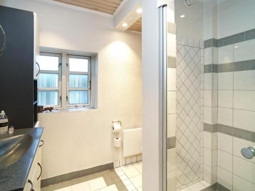 W łazience znajduje się prysznic i umywalka. w obiekcie Holiday home Jægerspris XLIII w mieście Jægerspris