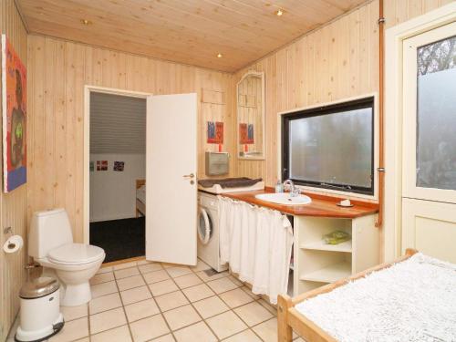 Kirke-Hyllinge的住宿－Holiday home Kirke Hyllinge X，一间带卫生间和水槽的浴室以及一台电视。