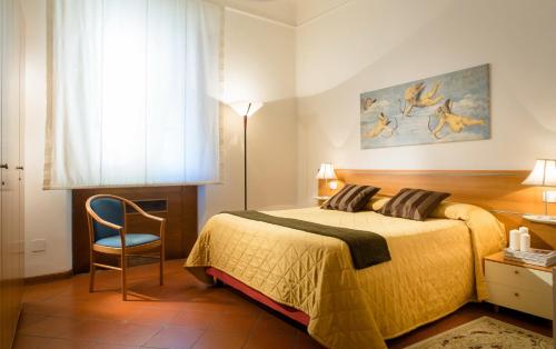 フィレンツェにあるレジデンスサンニッコロのベッドルーム1室(ベッド1台、椅子、窓付)