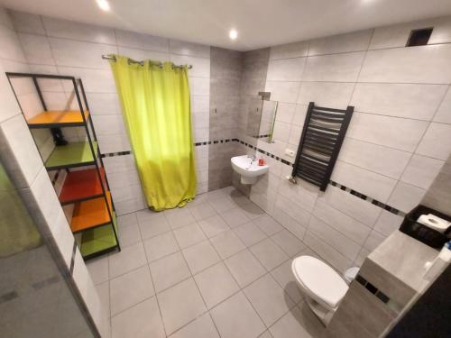 a bathroom with a toilet and a yellow shower curtain at Galeria kolorów pokój 4 osobowy in Łódź