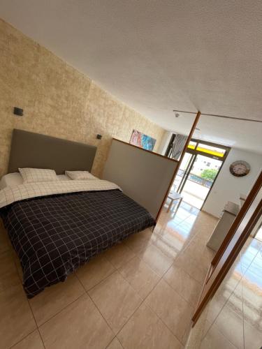 een slaapkamer met een bed met een zwart-witte deken bij Apartment Modern 2 Playa del Ingles in San Bartolomé