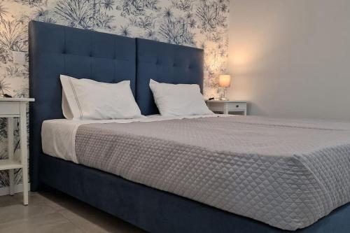 un letto blu con cuscini bianchi in una camera da letto di Casa de Férias_As Oliveiras III a Espinho