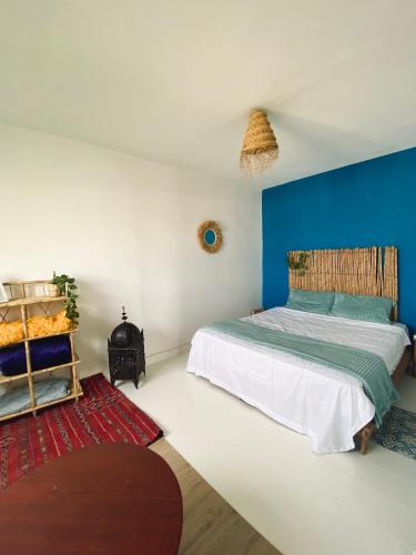 - une chambre dotée d'un lit avec un mur bleu dans l'établissement Appartement a ksar SGHIR en face du terminal passagers de Ferry port Tanger Med, à Ksar Sghir
