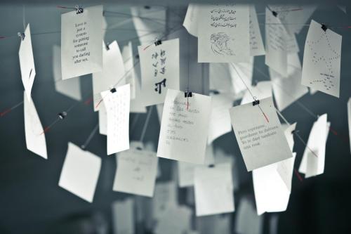 a bunch of papers hanging on a string at Hotel Suite Inn in Udine