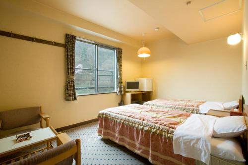 a hotel room with a bed and a window at Onyado Tsutaya in Kiso