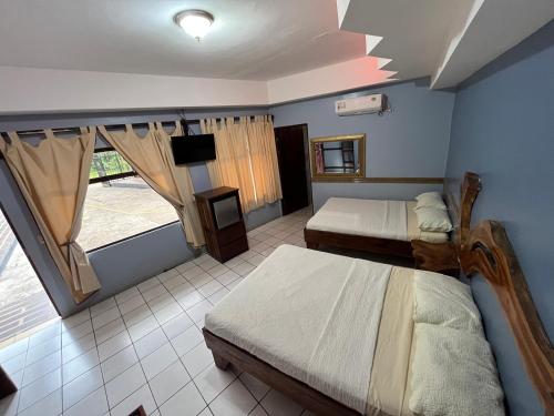 ein Schlafzimmer mit 2 Betten und einem TV. in der Unterkunft Hotel Wilson Tulipan Los Chiles in Los Chiles