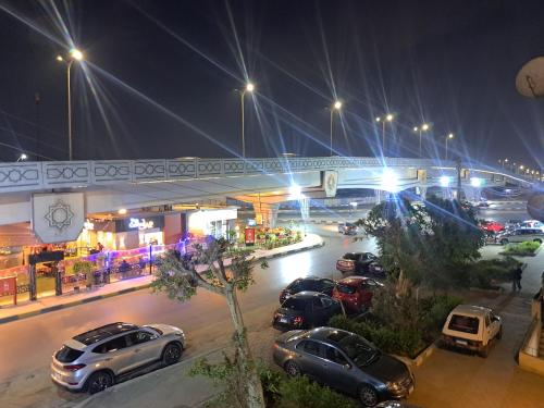 een groep auto's geparkeerd op een parkeerplaats 's nachts bij Hijaz Square Hotel in Caïro