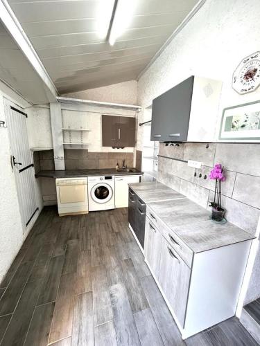 une grande cuisine avec des appareils blancs et du parquet dans l'établissement Provencal style home in Mediterranean seaside town, à La Londe-les-Maures