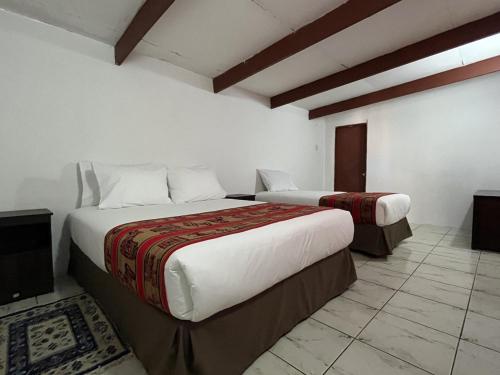 um quarto de hotel com duas camas num quarto em Ckoinatur Hostel em San Pedro de Atacama