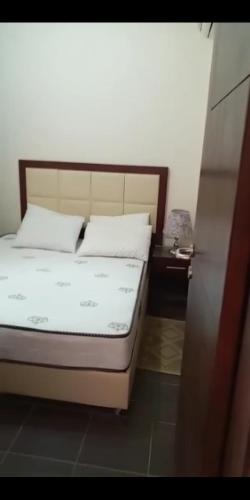 een bed met witte lakens en kussens in een kamer bij Your home in Sharm El Sheikh