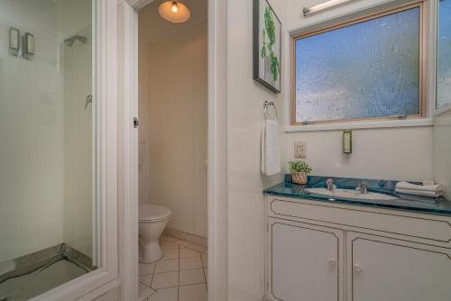 a bathroom with a sink and a toilet at Oceans 88 Whitianga Coastal Suites in Whitianga