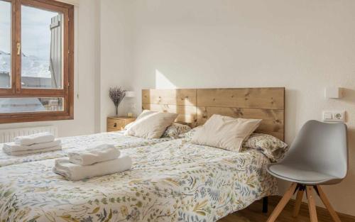 a bedroom with a bed with two towels on it at Apartamento Elurra Formigal in Formigal