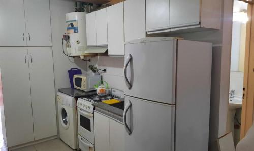 a kitchen with white cabinets and a white refrigerator at Departamento Citrino in Godoy Cruz