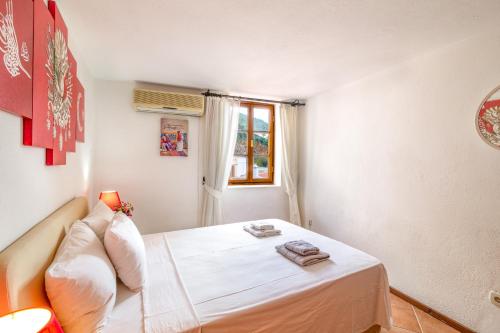 a small bedroom with a white bed and a window at SONSUZ in Kalkan