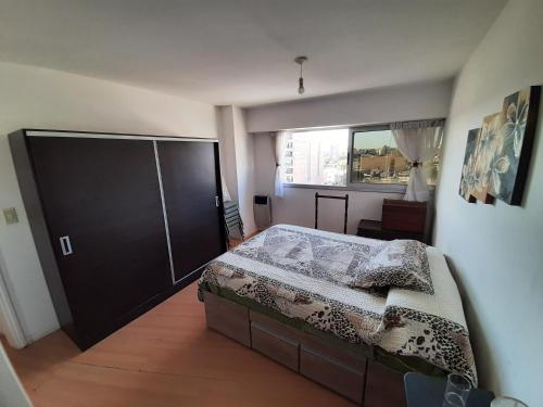 - une chambre avec un grand lit et une fenêtre dans l'établissement Departamento MeR, à Río Cuarto