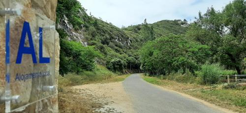 a dirt road with a sign on the side at Casas Du Rio in Maceira